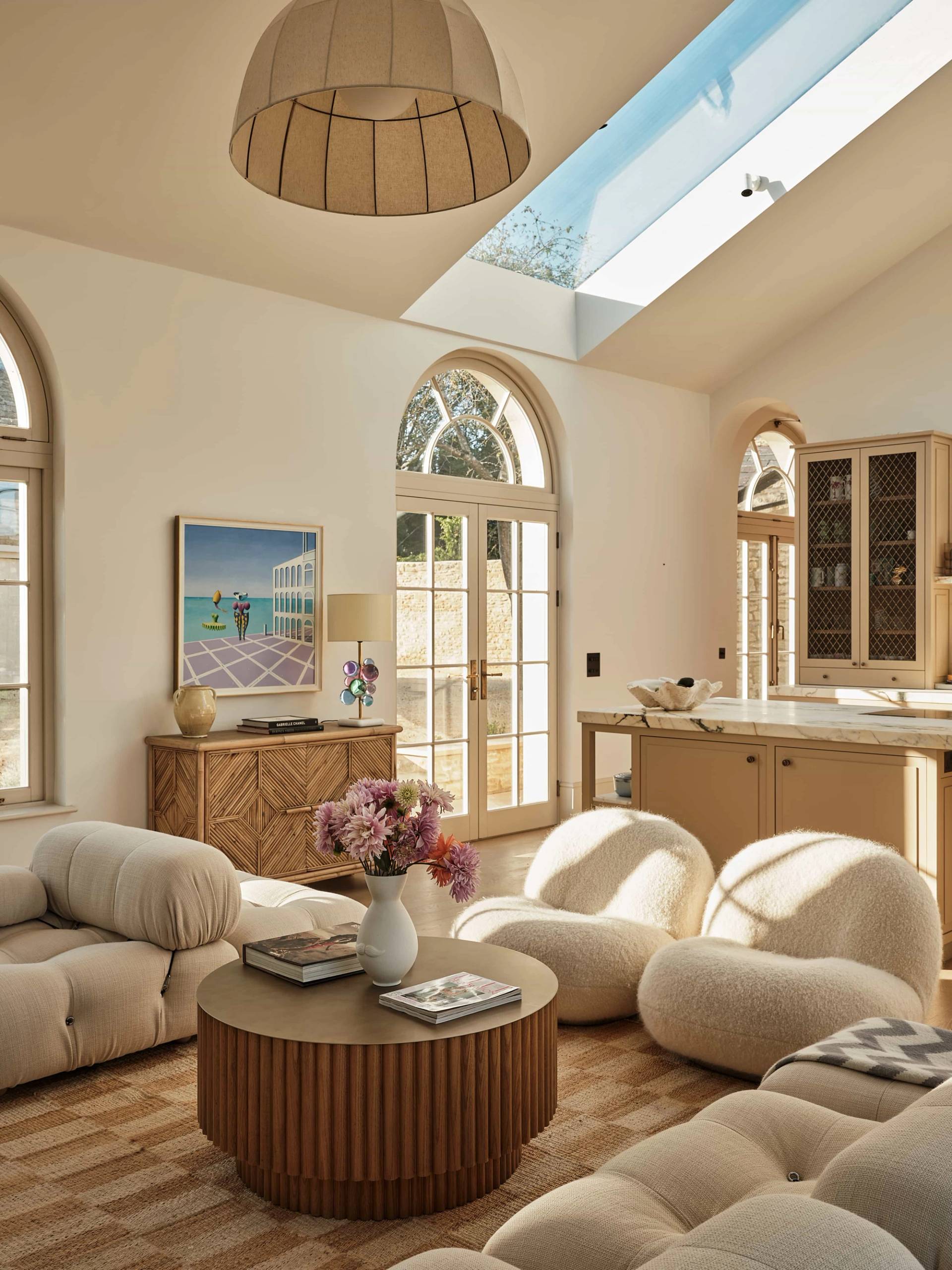 Sunlit vaulted open-plan living room shoot location in Shipton Under Wychwood, OX7 featuring bouclé sofas, arched French doors, and skylights, ideal for high-end furniture lookbooks via Love Locations.