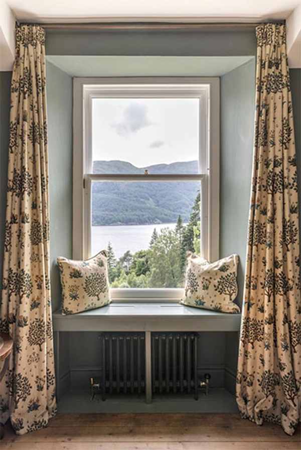 Glenstriven window seat overlooking the loch framed by curtains and soft light in the 1850s house