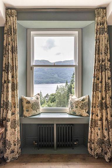 Glenstriven window seat overlooking the loch framed by curtains and soft light in the 1850s house