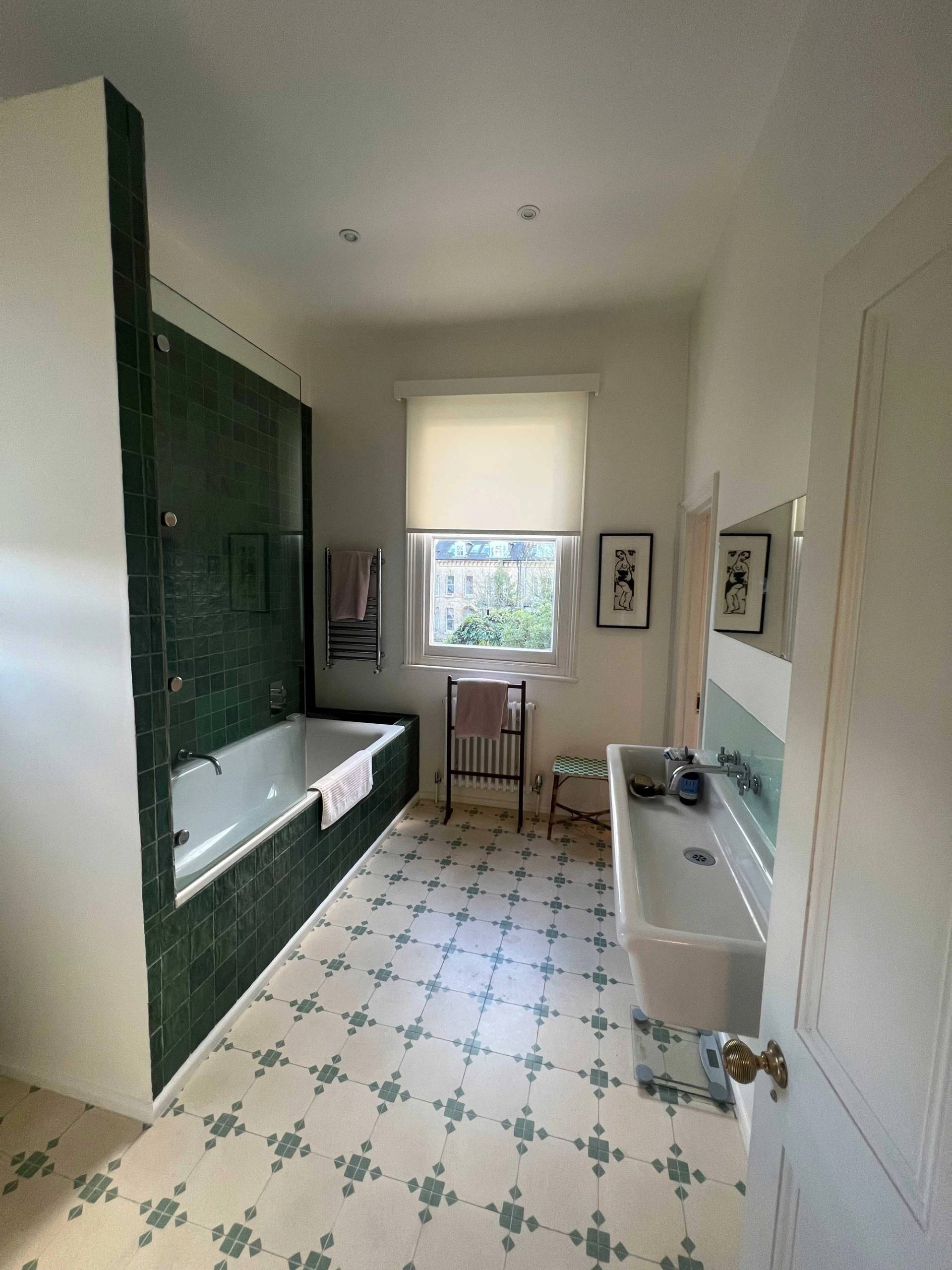 Family bathroom featuring a tub with deep forest green wall tiles, patterned floor tiles, and sash window light, ideal for personal care ads, Love Locations SE5.