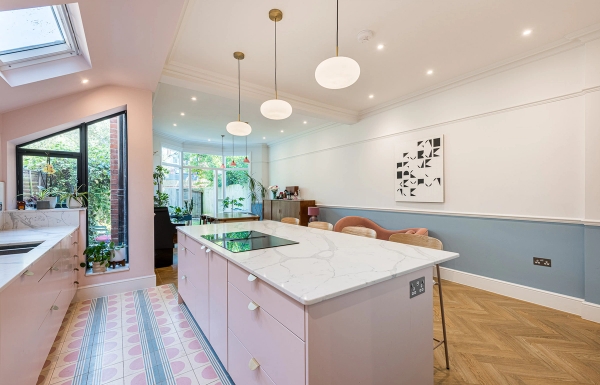 Modern pastel pink kitchen island with white marble worktops inside a bright architectural shoot space, listed on Love Locations.