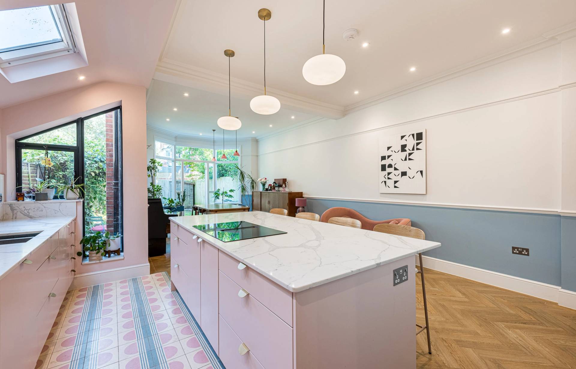 Modern pastel pink kitchen island with white marble worktops inside a bright architectural shoot space, listed on Love Locations.