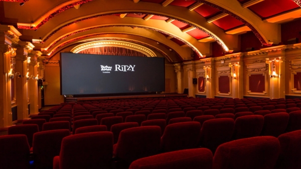 Wide front view of the historic cinema auditorium Screen 1 at The Ritzy in Brixton SW2, featuring plush red velvet seats and arched decorative ceilings, available via Love Locations.
