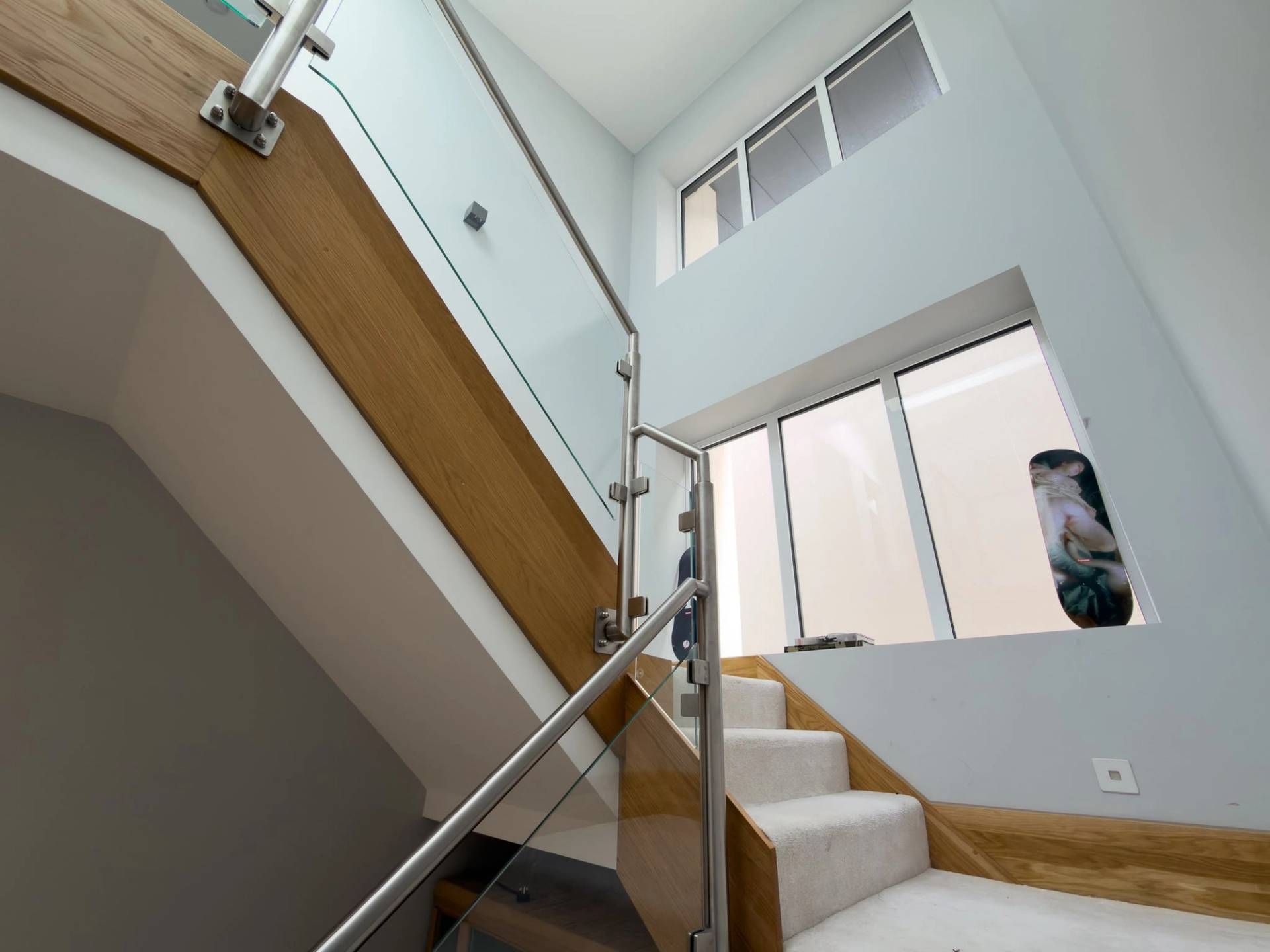 Contemporary oak and glass panelled staircase shoot location in Barnet EN4 via Love Locations, with high ceilings and light-filled windows.