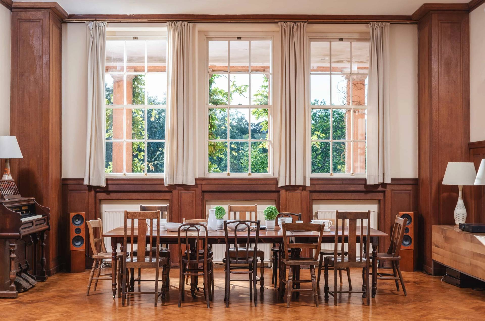 Bright formal dining room space with traditional wood panelling and dual-aspect windows in a Devon estate location from Love Locations.