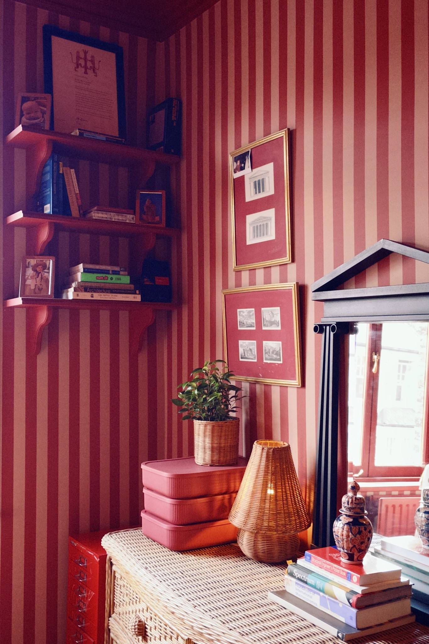 Dramatic study or sitting room featuring bold red striped wallpaper, packed bookshelves, and warm atmospheric lighting, ideal for interview backdrops, Love Locations.