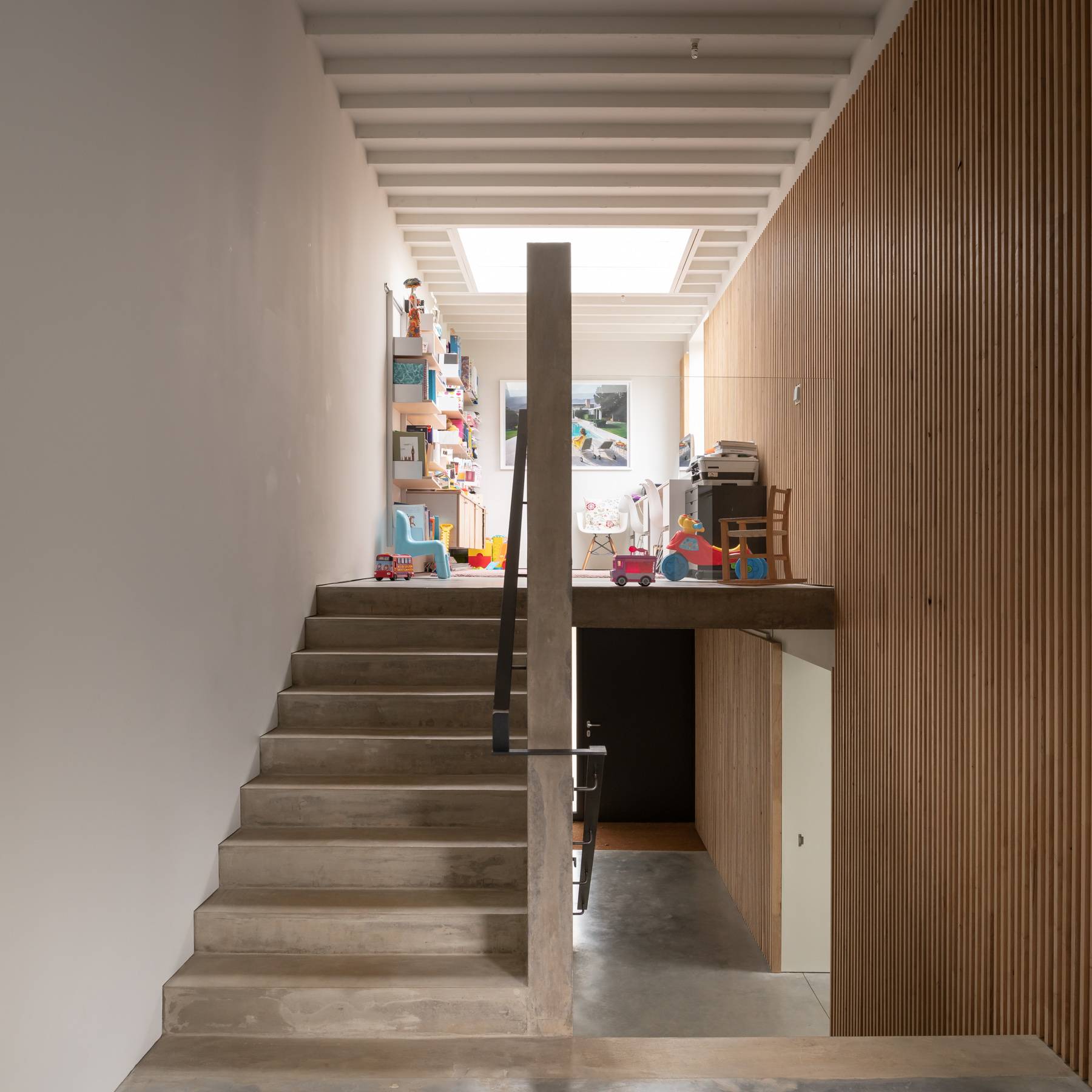 Monolithic raw concrete staircase illuminated by a ceiling skylight window, Love Locations BN3.