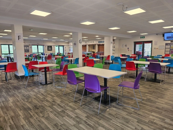 Modern academy school canteen location with bright multi-colored chairs and spacious dining area for film hire in High Wycombe, HP13 via Love Locations.