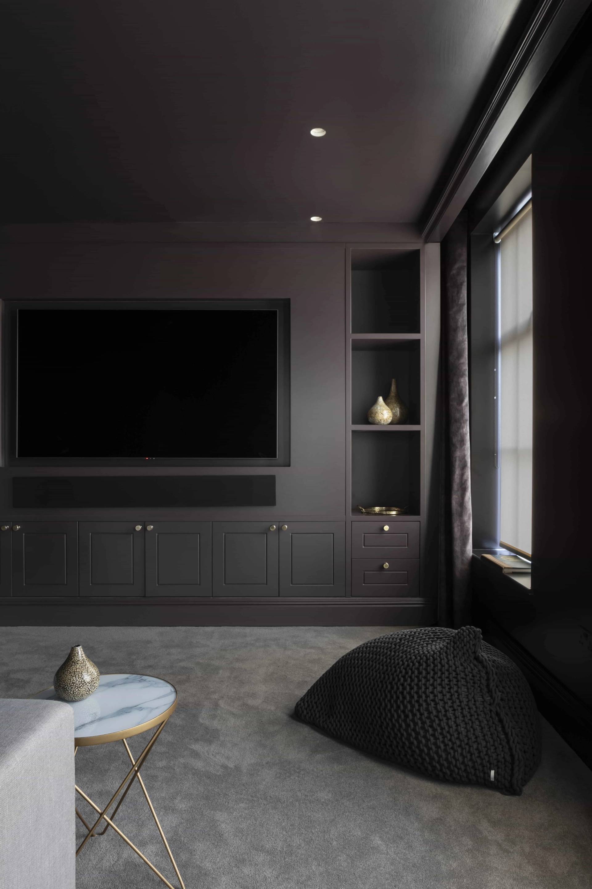 Dark moody cinema room featuring a wall-mounted screen, dark grey walls, and plush carpet flooring, Love Locations HP18.