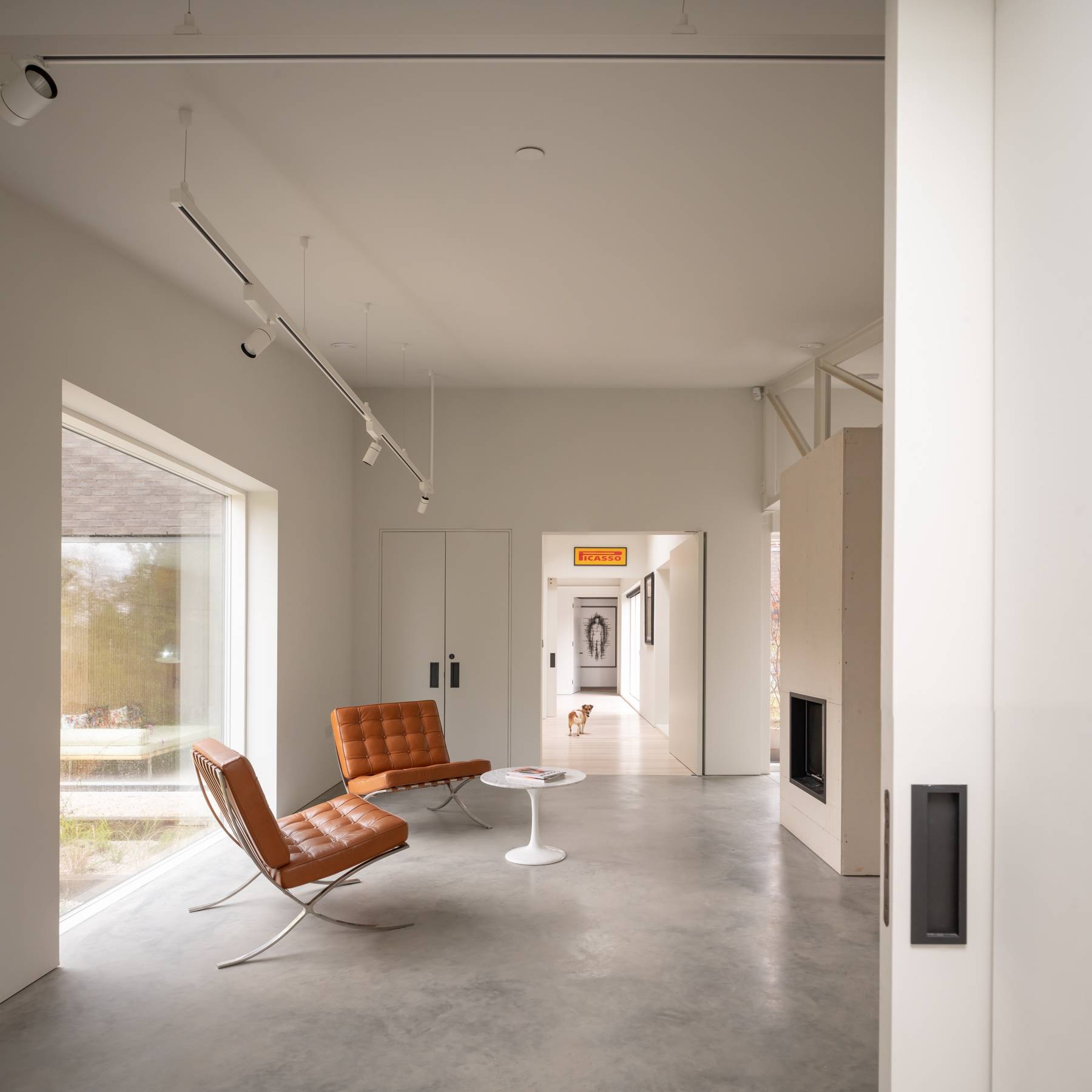 Minimalist lounge corner featuring cognac leather Barcelona chairs and polished concrete floor, Love Locations BN3.