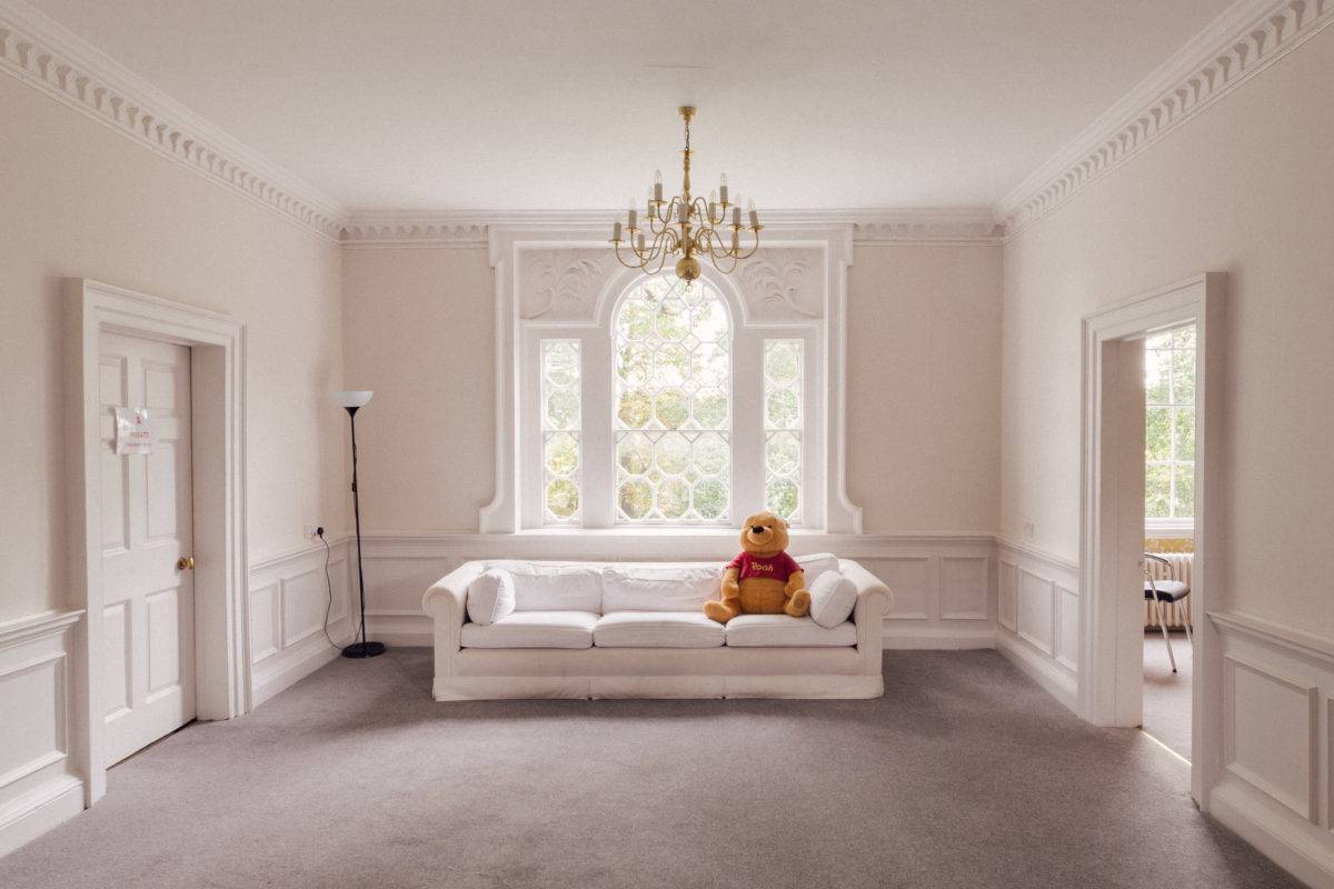 Grand room featuring an ornate arched window bay, white sofa, neutral carpet, and white wall panelling, perfect for bridal campaigns, Love Locations SE15.