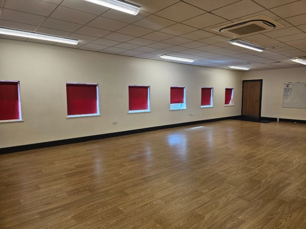 Large empty school hall studio with minimalist interiors and red window blinds for controlled production setups, Love Locations.