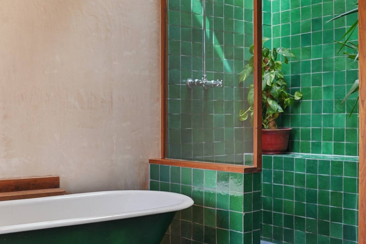 Emerald green glazed subway tiled bathroom wall and freestanding bath, perfect for skincare product marketing, Love Locations E7.