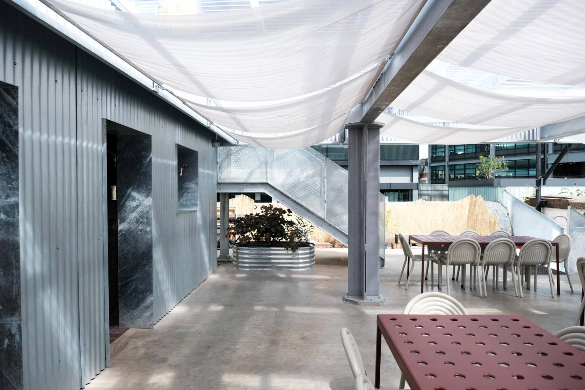 Open-air rooftop terrace shoot space showing steel staircase access and covered seating areas from Love Locations.