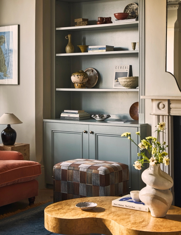 Living room alcove featuring painted grey built-in cabinets, patterned footstool, and decorative ceramics, Love Locations SE21.