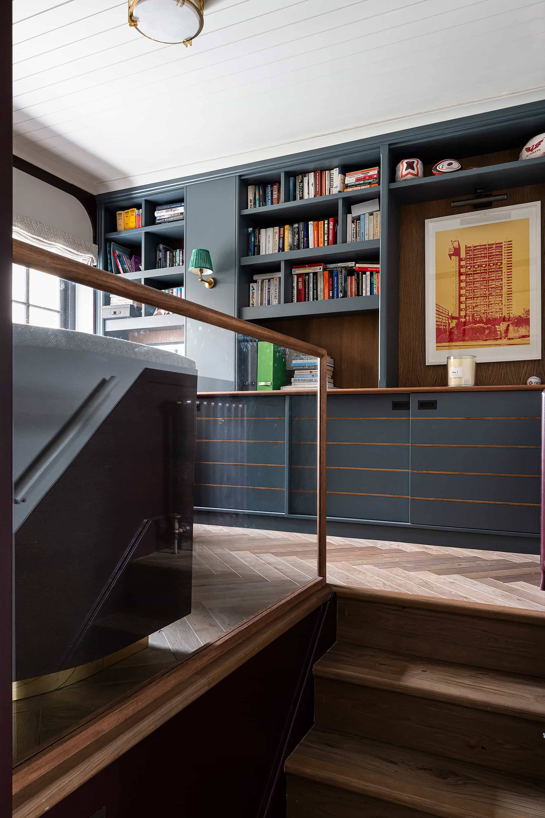 Gallic style library landing with built-in dark blue shelving, desk, and glass balustrades, perfect for home office ad shoots, Love Locations.