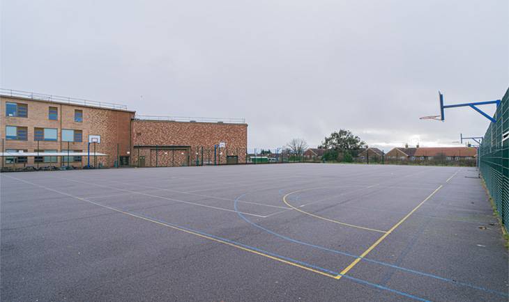 Large outdoor school yard and sports ground film location in Hove BN3 with red-brick building backdrop from Love Locations.