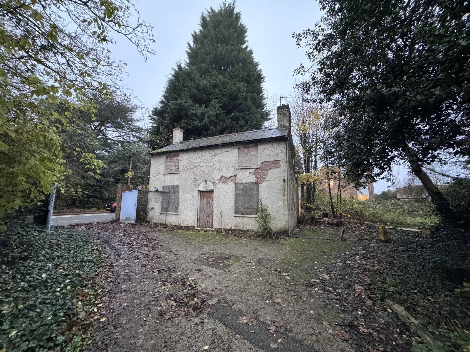 Boarded-up abandoned cottage exterior with peeling cream render, a perfect derelict filming location in Nottinghamshire, listed with Love Locations.