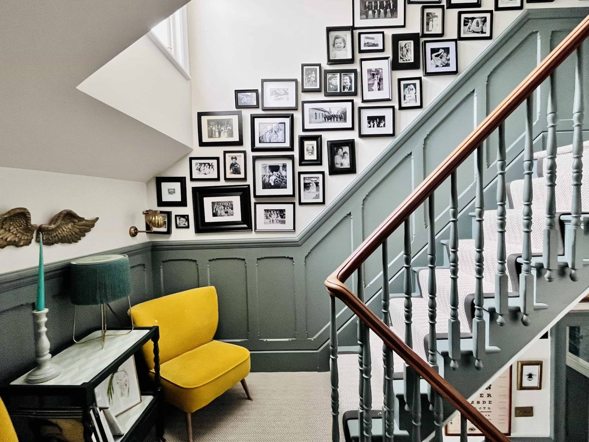 Staircase hallway transition featuring grey wall panelling, yellow accent armchair, and gallery wall frames, Love Locations TW11.