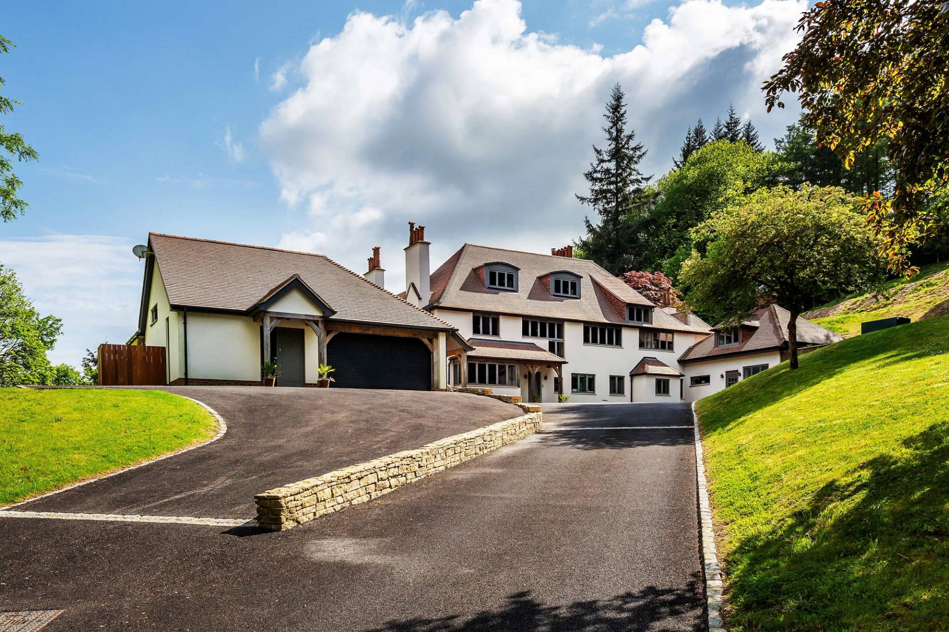 Sweeping asphalt estate driveway leading up to a grand country house mansion, perfect for luxury automotive commercials, Love Locations.