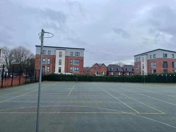 Love Locations outdoor tarmac sports court Reading: Hardstanding netball and basketball court with residential block background, perfect for urban youth dramas and sports filming.