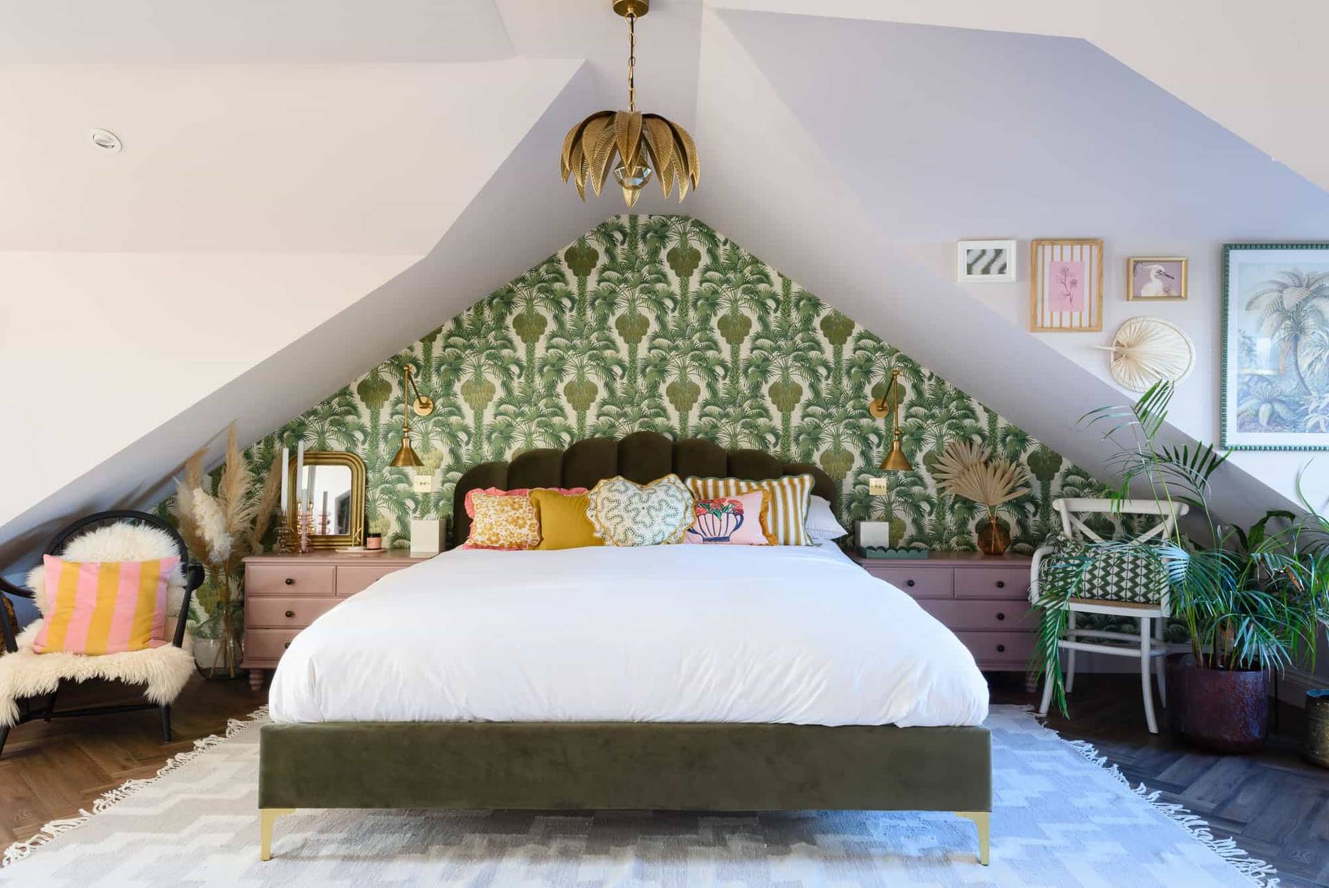 Attic bedroom suite featuring a William Morris botanical wallpaper alcove and green upholstered bed, Love Locations TW11.