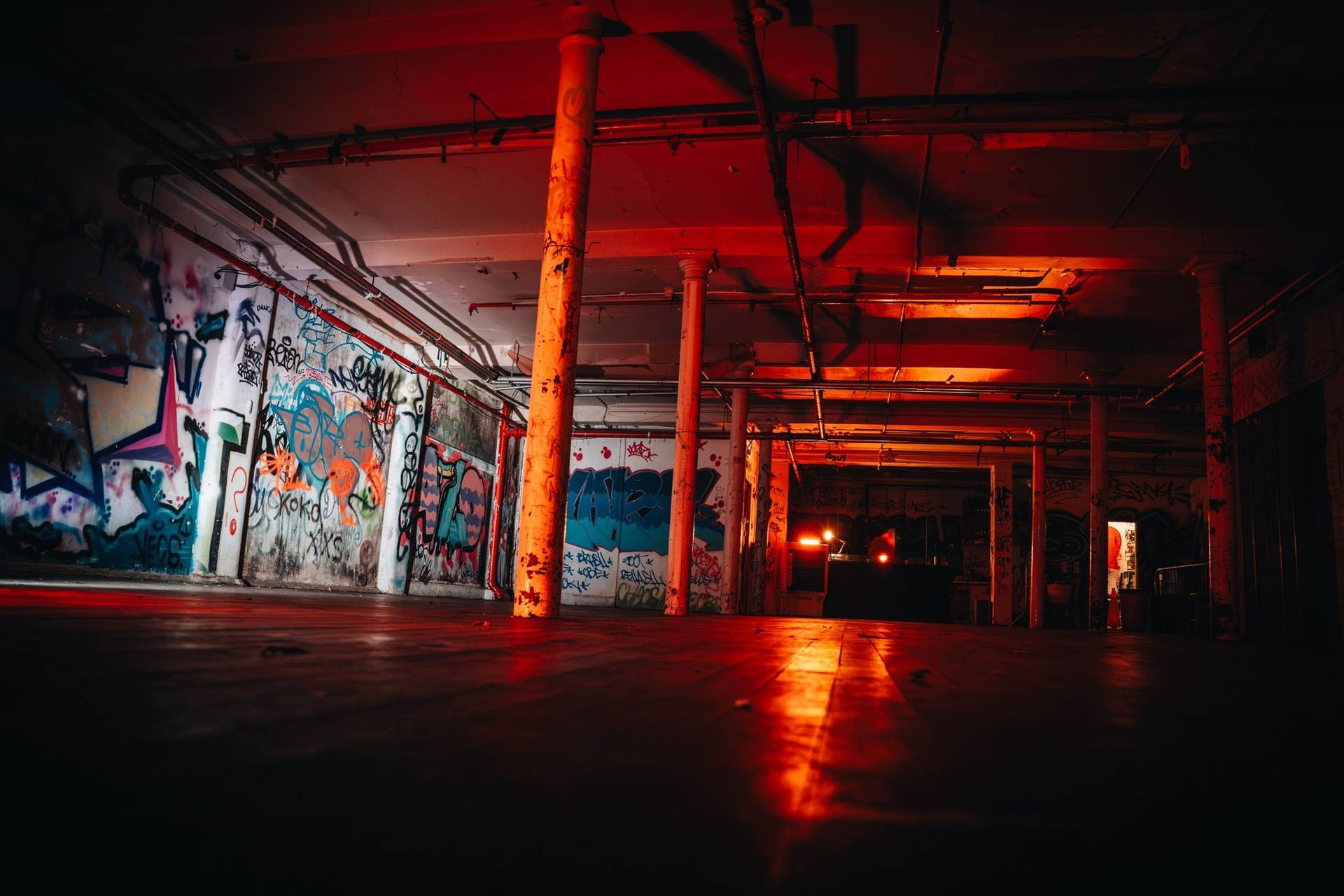 Broad perspective of an industrial club venue film location in Cheetham Hill Manchester M3 by Love Locations, with painted support pillars and intense red lighting.