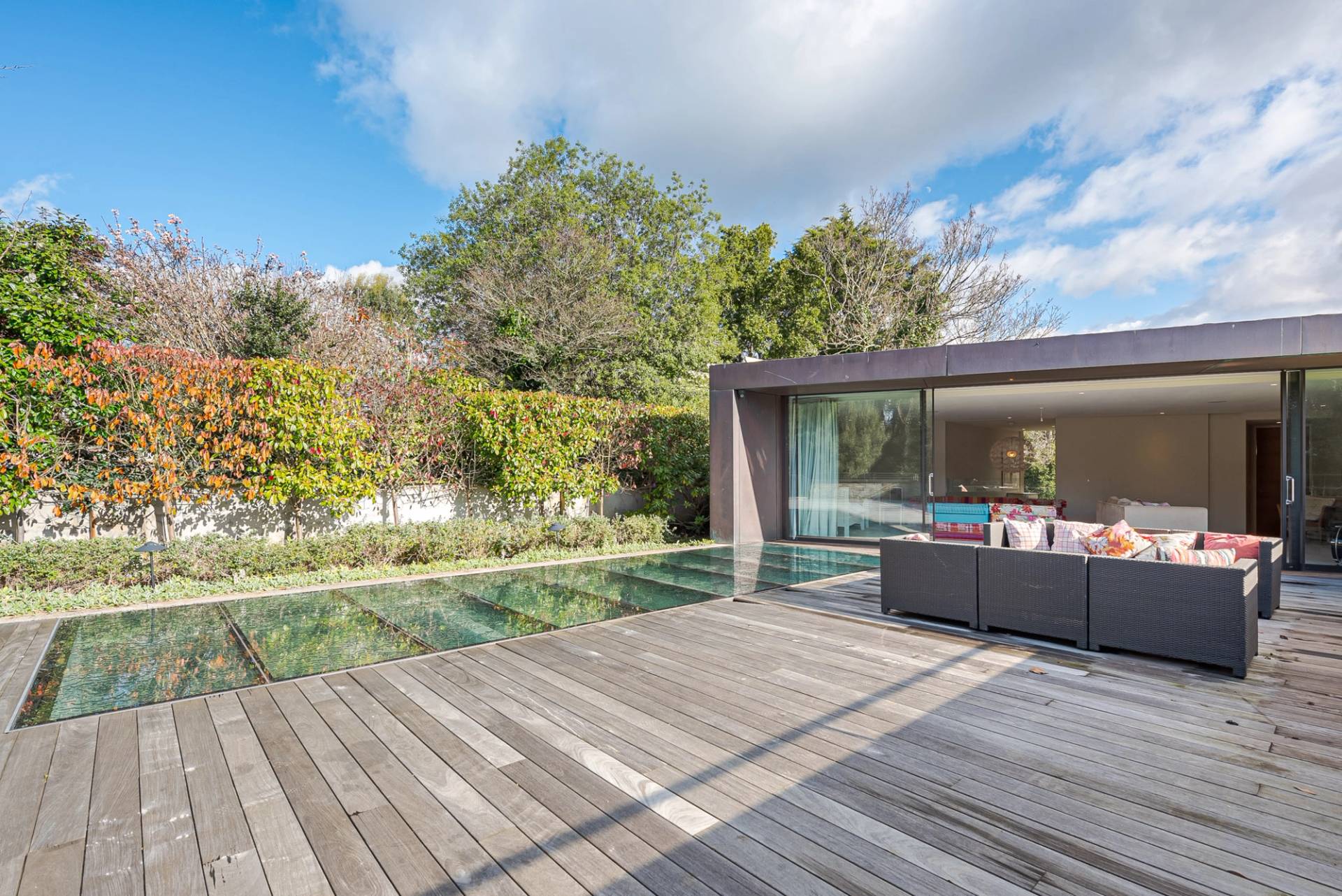 Rooftop sun terrace featuring a glass skylight floor looking down into the indoor swimming pool below, Love Locations KT2.