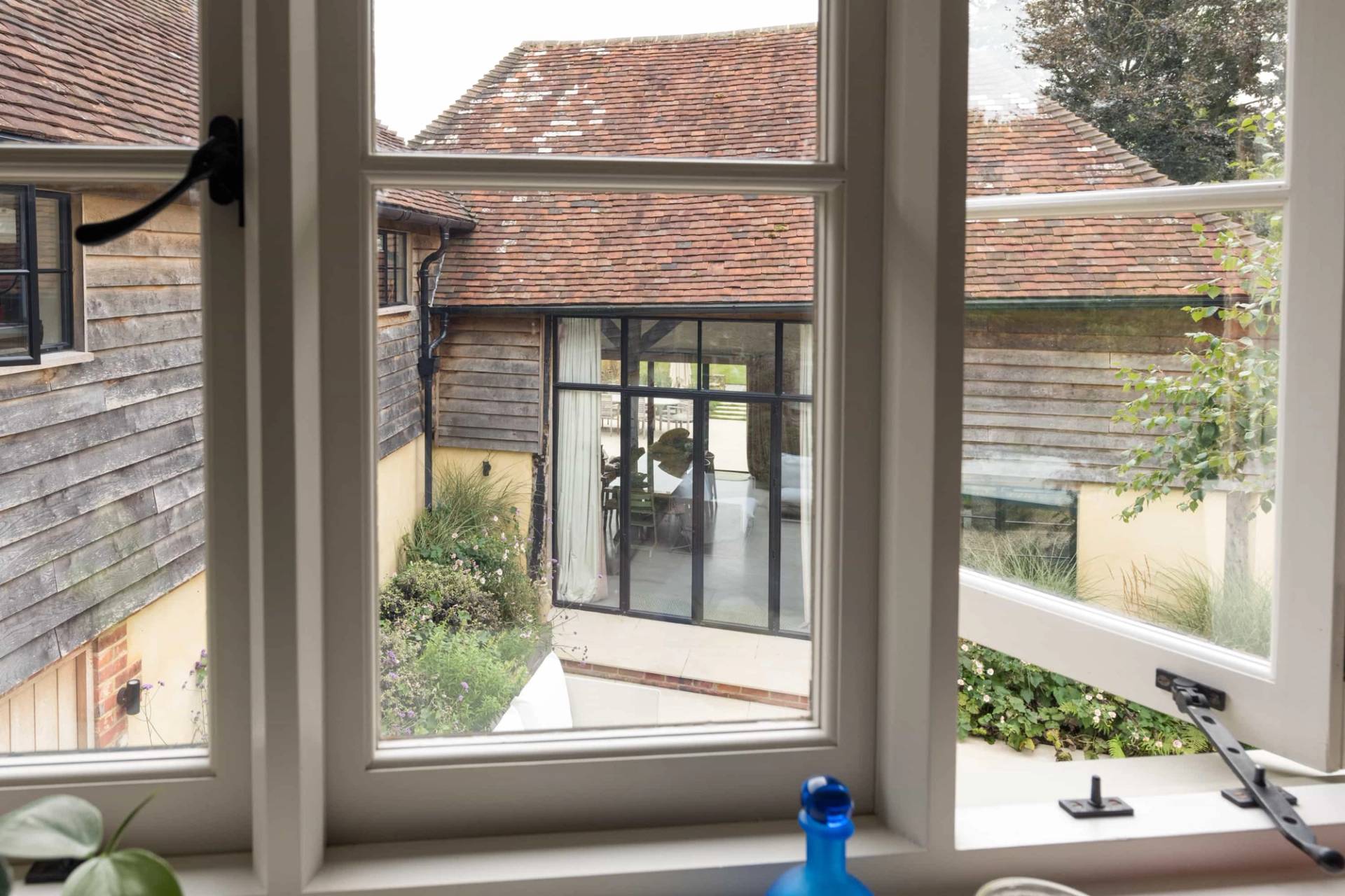 Close-up view through a traditional glass sash window looking onto stone courtyard walls, Love Locations GU28.