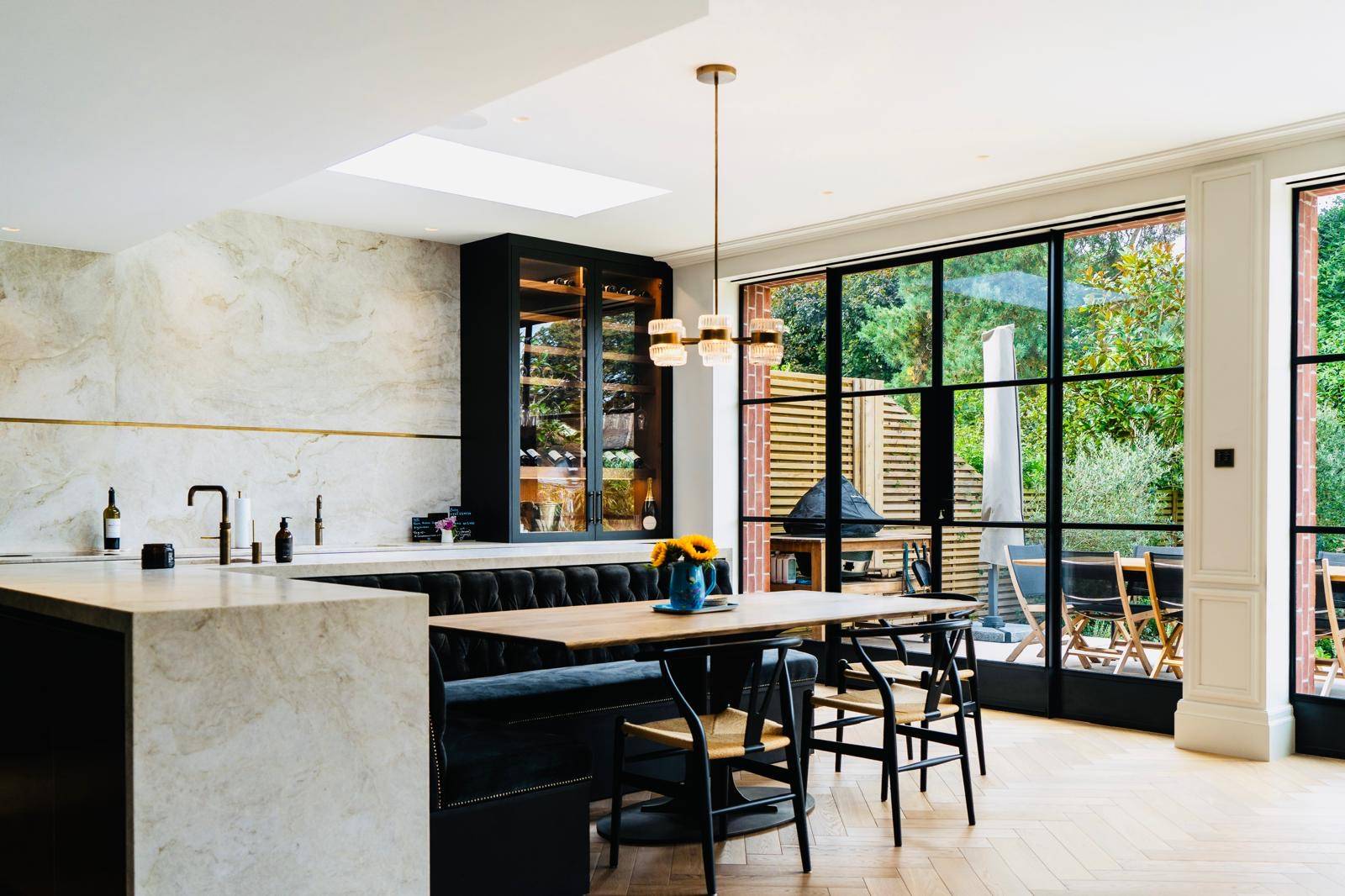 Modern open-plan kitchen and dining layout with black banquette seating and Crittall windows, Love Locations TW11.