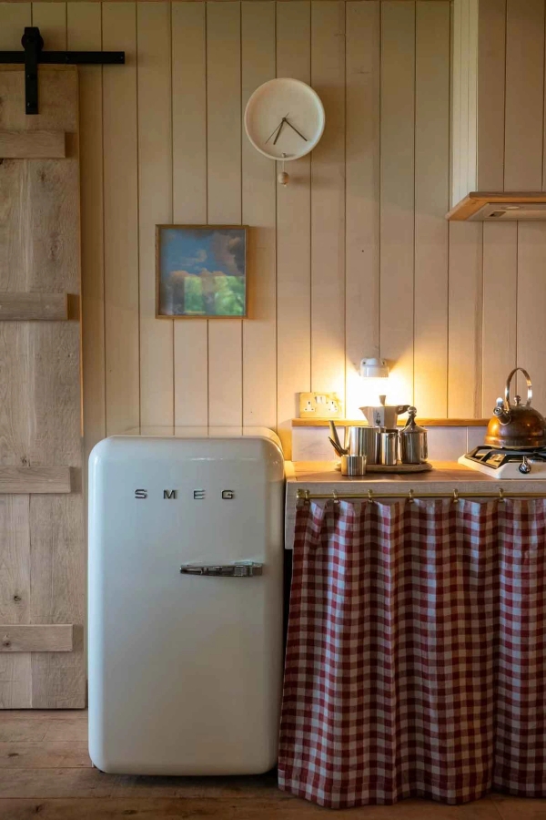 Vintage retro Smeg fridge styled next to a country-style checkered fabric worktop cover for editorial food media filming, Love Locations Herefordshire.