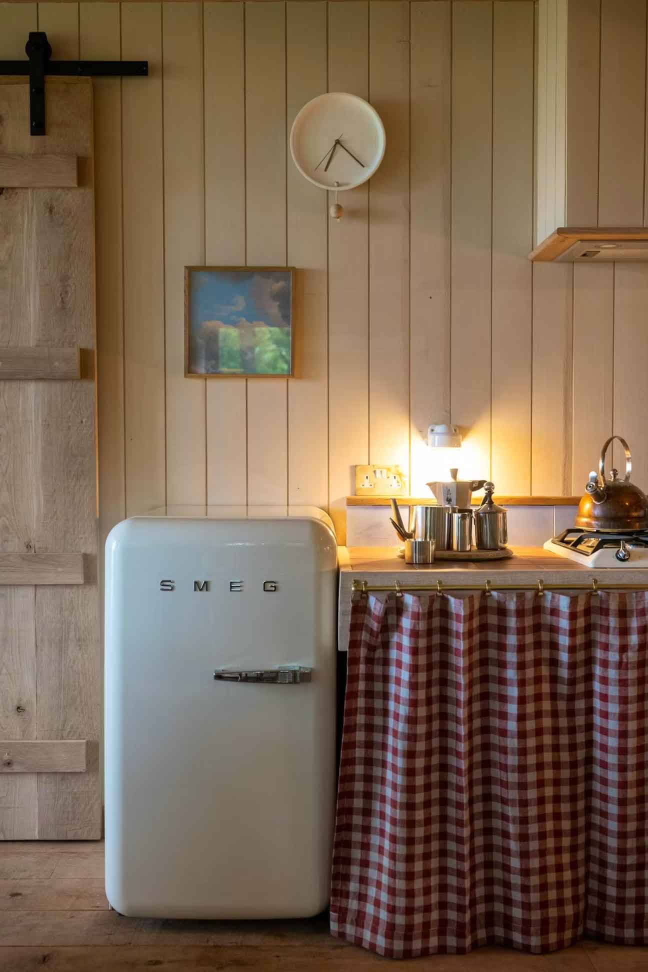 Vintage retro Smeg fridge styled next to a country-style checkered fabric worktop cover for editorial food media filming, Love Locations Herefordshire.