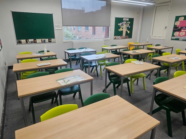 Bright empty classroom location space with student desks and display boards for film and TV production, listed by Love Locations.