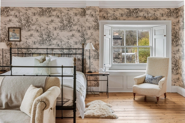 Four-poster bed frame set in a bedroom with patterned toile wallpaper and sash windows, Love Locations KY15.