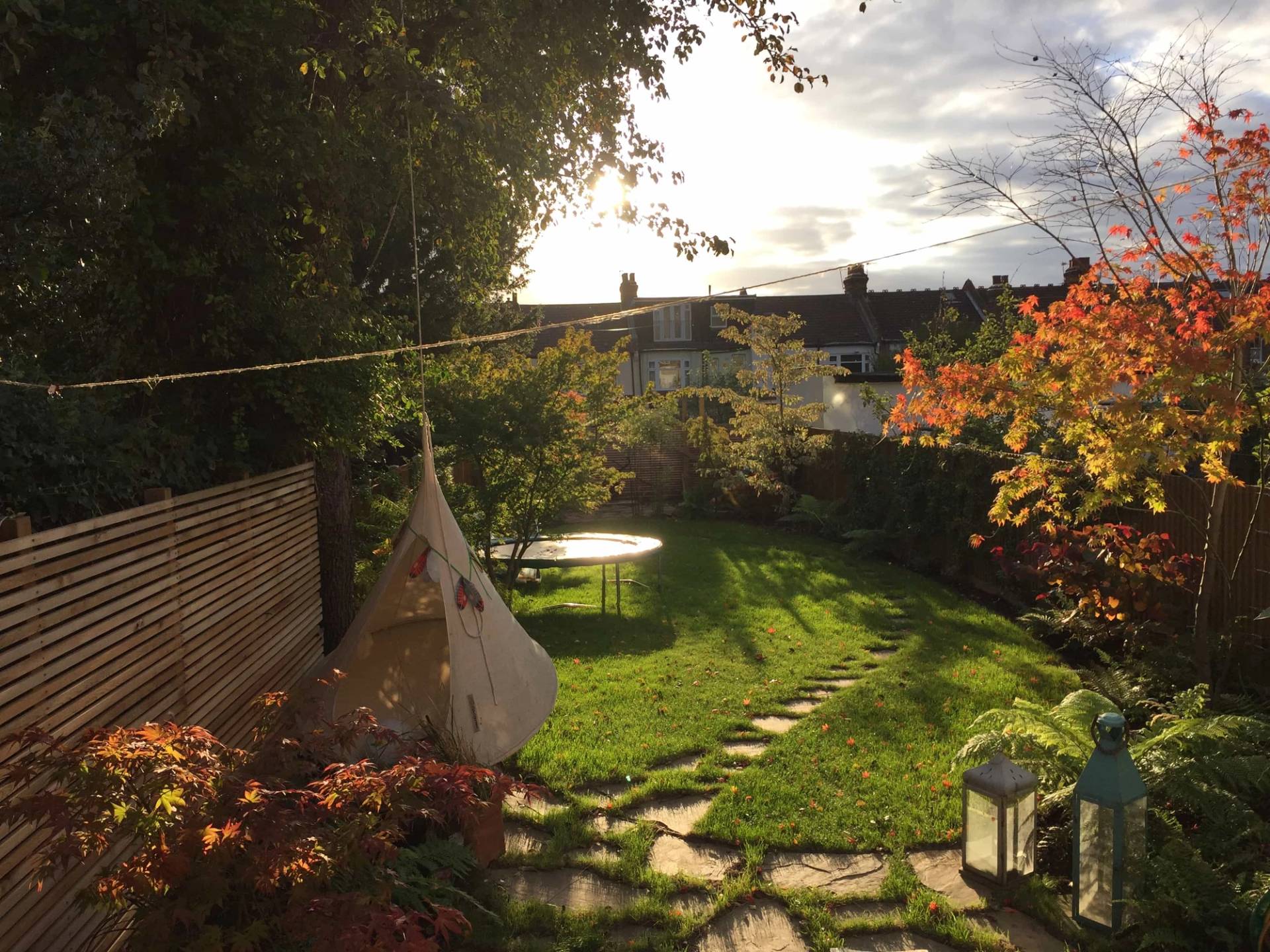 Lush green rear garden lawn with stepping stone pathway and garden teepee tent, perfect for family outdoor shoots, Love Locations N13.