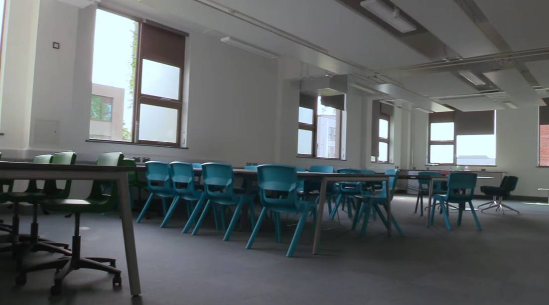 Love Locations modern science laboratory RG30: Adaptable classroom space featuring high laboratory benches and teal stools, perfect for secondary school scenes in films and television.
