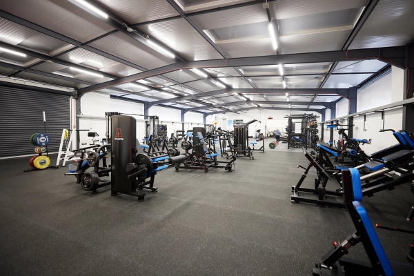 Extensive view of a large, high-ceilinged modern gym facility packed with professional training equipment, Love Locations SO23.
