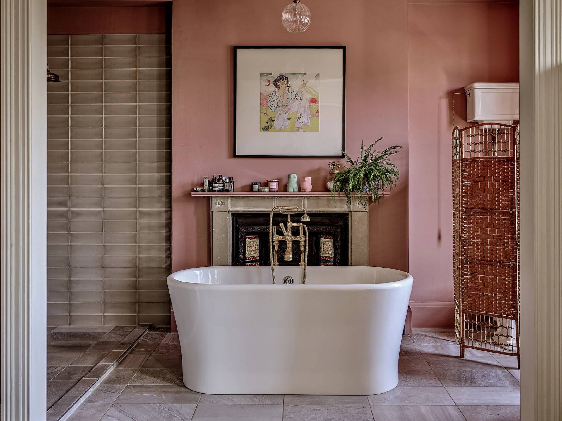 Dusty pink bathroom featuring a white roll-top freestanding tub, marble fireplace, and tiled floors, ideal for skincare commercials, Love Locations ME13.