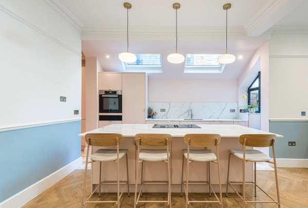 Bright contemporary kitchen studio layout showing island breakfast bar stools and stylish pendant lighting, managed by Love Locations.
