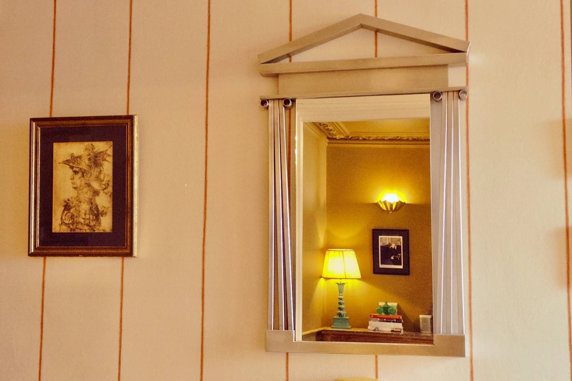 Ornate architectural wall mirror with classical pediment detailing reflecting a warm interior room in TW7, Love Locations.