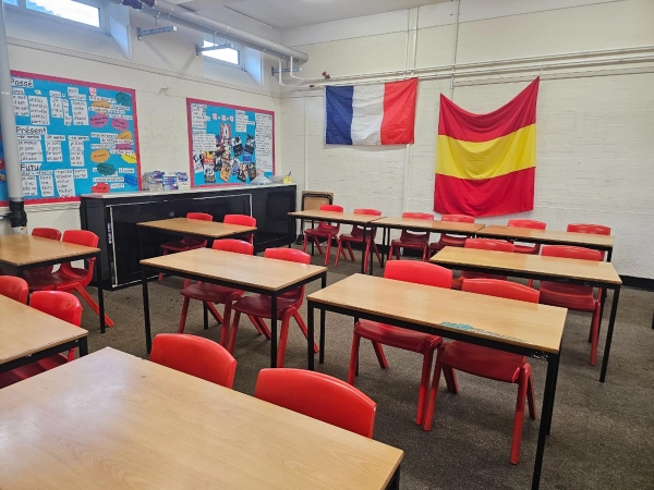 Modern academy school language classroom location space featuring international flags and red student chairs, curated by Love Locations HP13.
