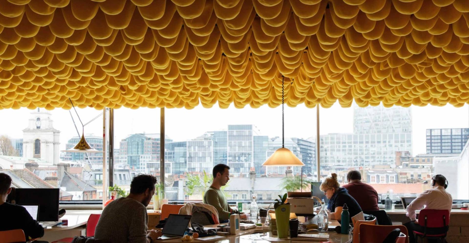 Bright creative office space with floor-to-ceiling windows and textured orange ceiling in Whitechapel London E1 – love locations