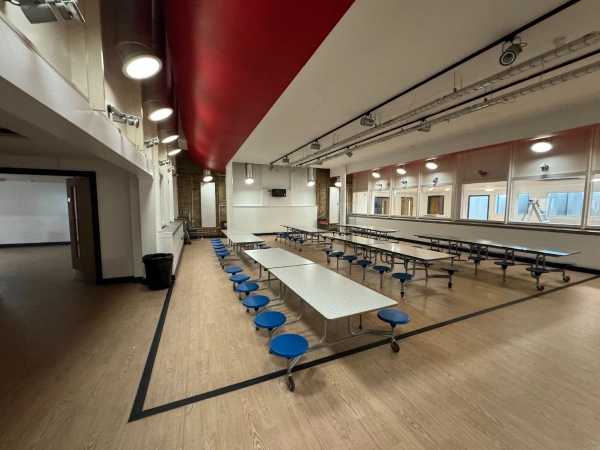 Love Locations bright school canteen space EN4: Educational dining hub featuring long communal seating layouts and distinctive red ceiling architecture, perfect for youth-targeted brand campaigns.