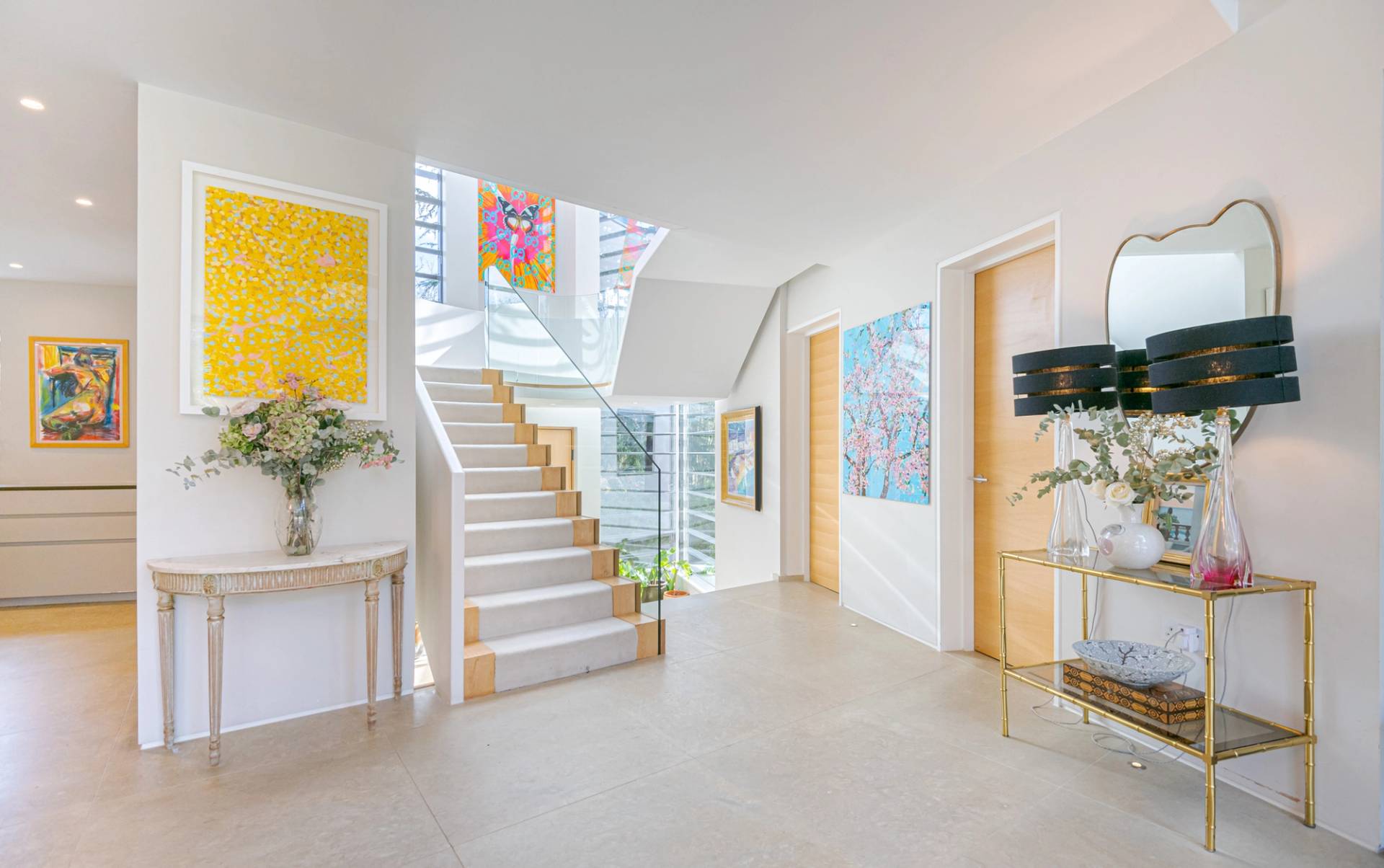 Bright entrance hall with light oak doors, glass balustrade staircase, and modern wall artwork, Love Locations KT2.