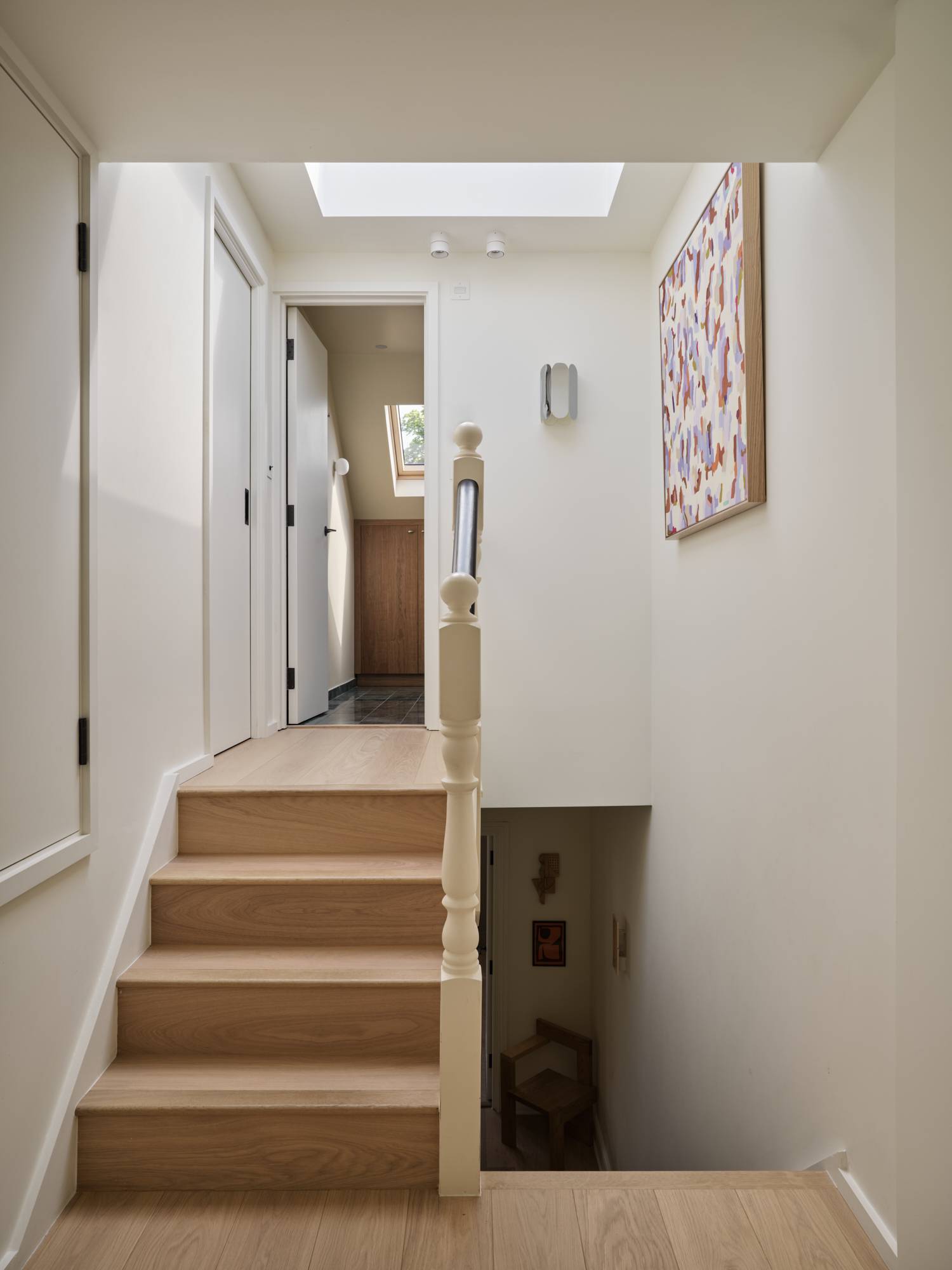 Love Locations bright residential corridor Lewisham: Upper hallway landing area filled with soft natural light, highlighting clean white doors and oak floor boundaries.