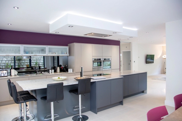 Contemporary kitchen breakfast bar setup with integrated ovens and distinct purple wall accents, perfect for editorial food media filming, Love Locations.