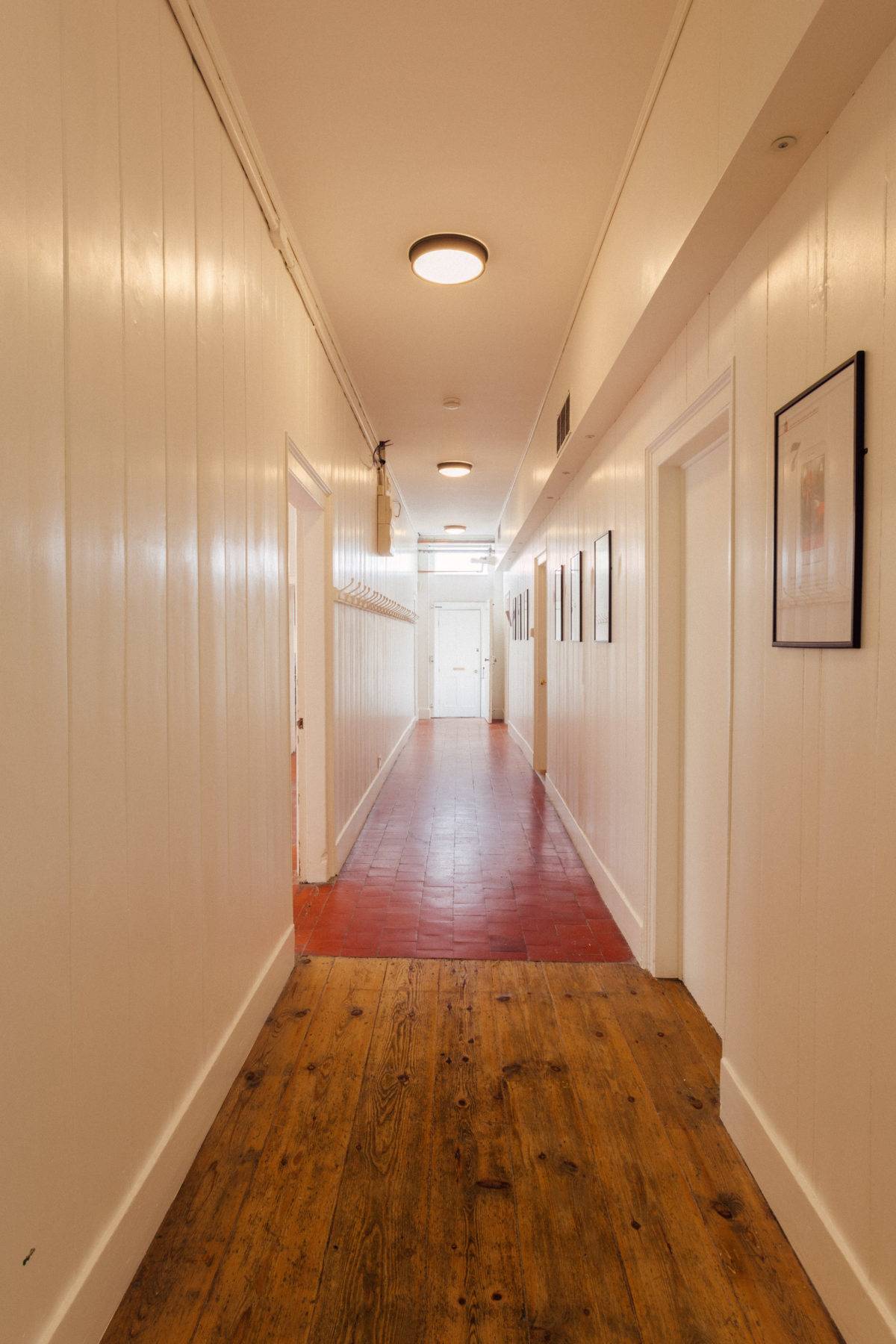 Long wood-panelled corridor featuring warm floorboards and classic ceiling fixtures, ideal for commercial film backdrops, Love Locations SE15.