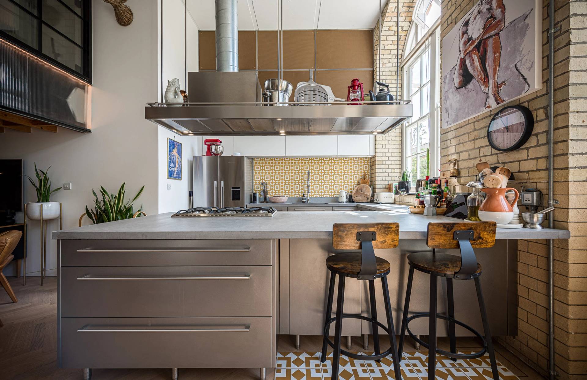 High-end kitchen island unit with bar stools under industrial extraction hoods for cooking shoots, Love Locations London Bridge.