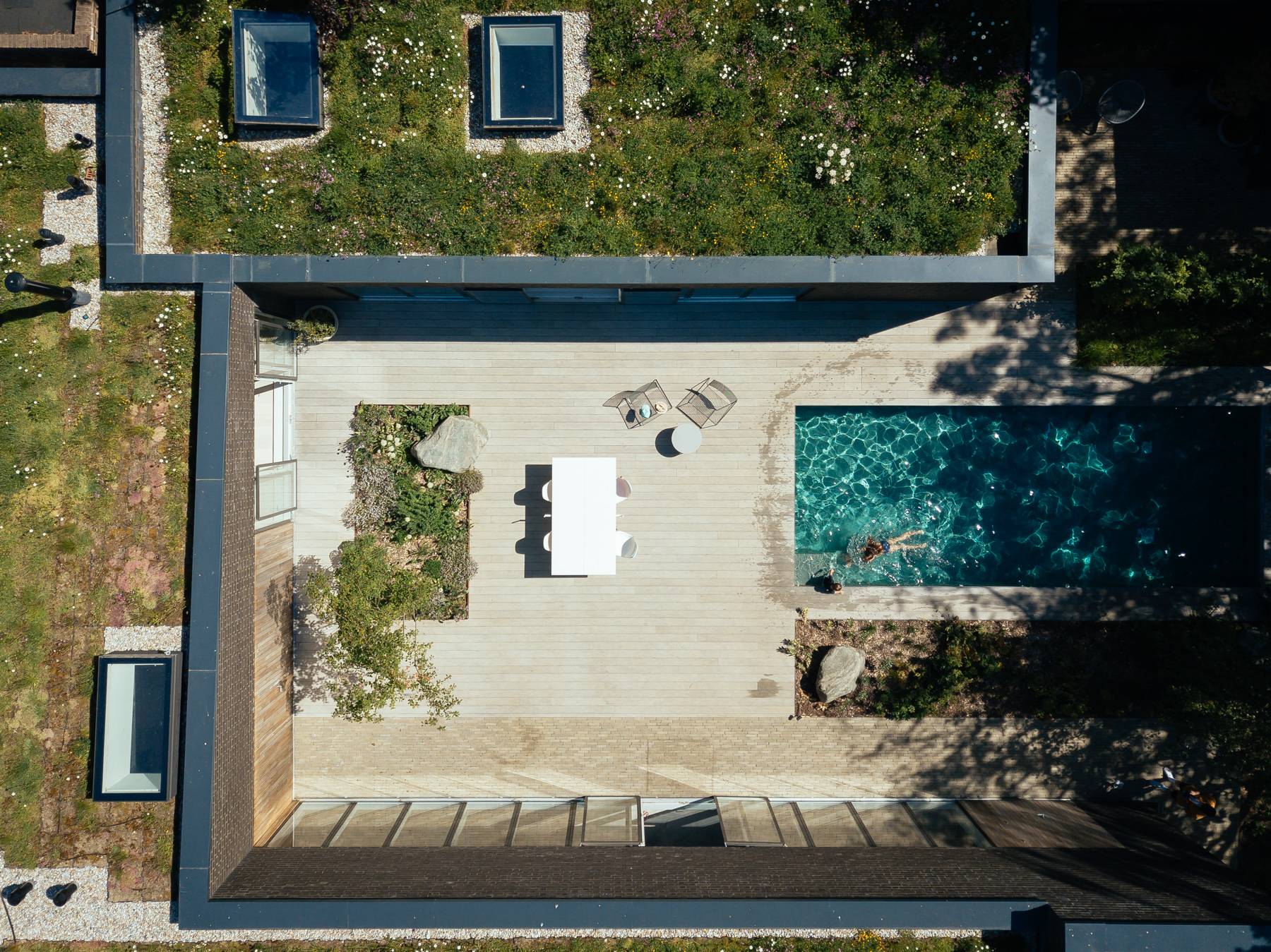 Top-down aerial view of a private courtyard patio, swimming pool, and sedum green roof, Love Locations BN3.