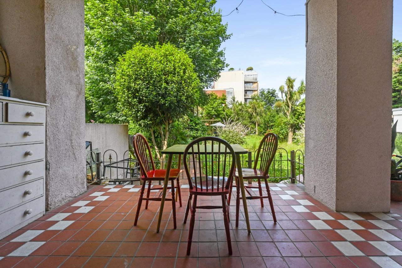 Covered garden patio terrace set with wooden dining chairs and red floor tiles, ideal for outdoor dining shoots, Love Locations E7.